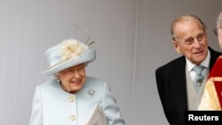 Britain's Queen Elizabeth II, and Prince Philip wait for the arrival by open carriage of Princess Eugenie of York and Jack Brooksbank following their wedding in St George's Chapel, Windsor Castle, near London, Britain, Oct. 12, 2018.