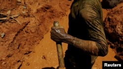 A garimpeiro uses a stick as an accelerator for a diesel engine while working a wildcat mine, also known as garimpo, at a deforested area of Amazon rainforest in Brazil, Aug. 6, 2017.