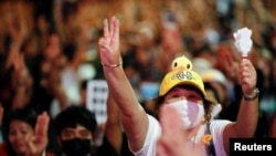 Pro-democracy activists show the three-finger salute as they protest after the constitutional court's ruling on Prime Minister Prayuth Chan-Ocha's conflict of interest case, in Bangkok, Thailand, Dec. 2, 2020. 
