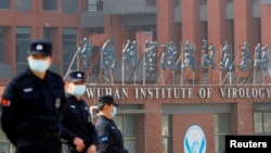 FILE - Security personnel keep watch outside the Wuhan Institute of Virology during the visit by the World Health Organization (WHO) team tasked with investigating the origins of the coronavirus disease, in Wuhan, Hubei province, China, Feb. 3, 2021.