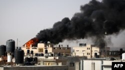 Густ, црн чад се издига од пожар во зграда предизвикана од израелско бомбардирање во Рафа во јужниот дел на појасот Газа, на 10 мај 2024 година, во услови на тековен конфликт меѓу Израел и палестинското движење Хамас (Фото: АФП)