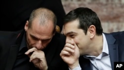 PM Alexis Tsipras (kanan) berbicara dengan Menkeu Yunani Yanis Varoufakis di Athena (18/2). Yunani menjanjikan serangkaian reformasi keuangan kepada para kreditor Uni Eropa. 