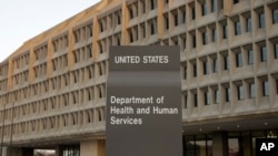 FILE - The Department of Health and Human Services building is seen in the evening in Washington.