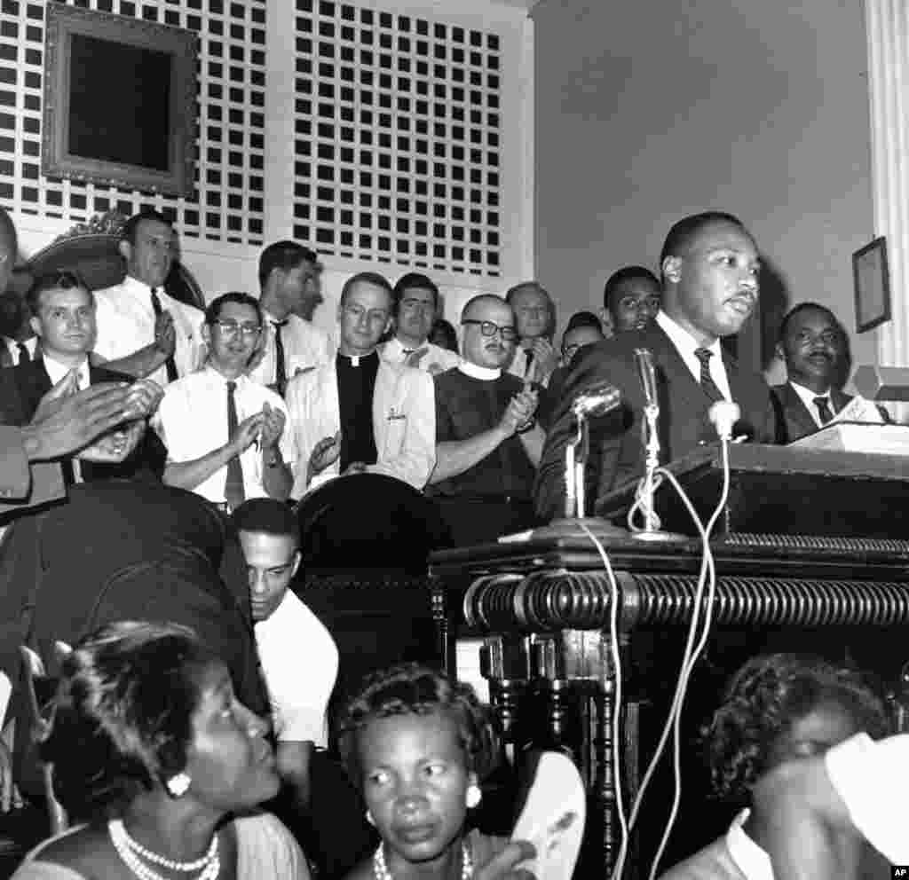 A group of clergymen from the northern states applaud Southern Christian Leadership Conference president Martin Luther King Jr. as he speaks at a church in Albany, Georgia, August 28, 1962.