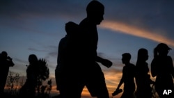 Silueta de personas que camina por el cerro El Volcán durante la puesta de sol en El Hatillo de Caracas, el 25 de abril de 2021.