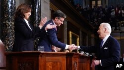 ভাষণ শেষে প্রেসিডেন্ট বাইডেন হাউস স্পিকার মাইক জন্সনের সাথে করমর্দন করছেন।