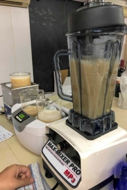 FILE - A worker blends supplement drinks at an industrial building in Hong Kong, Dec. 1, 2019.