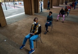 FILE - Off-duty metro police officers queue to be screened and tested for COVID-19 in Johannesburg, South Africa, May 7, 2020.