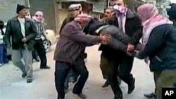 In this still image taken from video protesters in a Damascus suburb purportedly carry a wounded comrade Friday, December 30, 2011. Image content not independently verifiable.