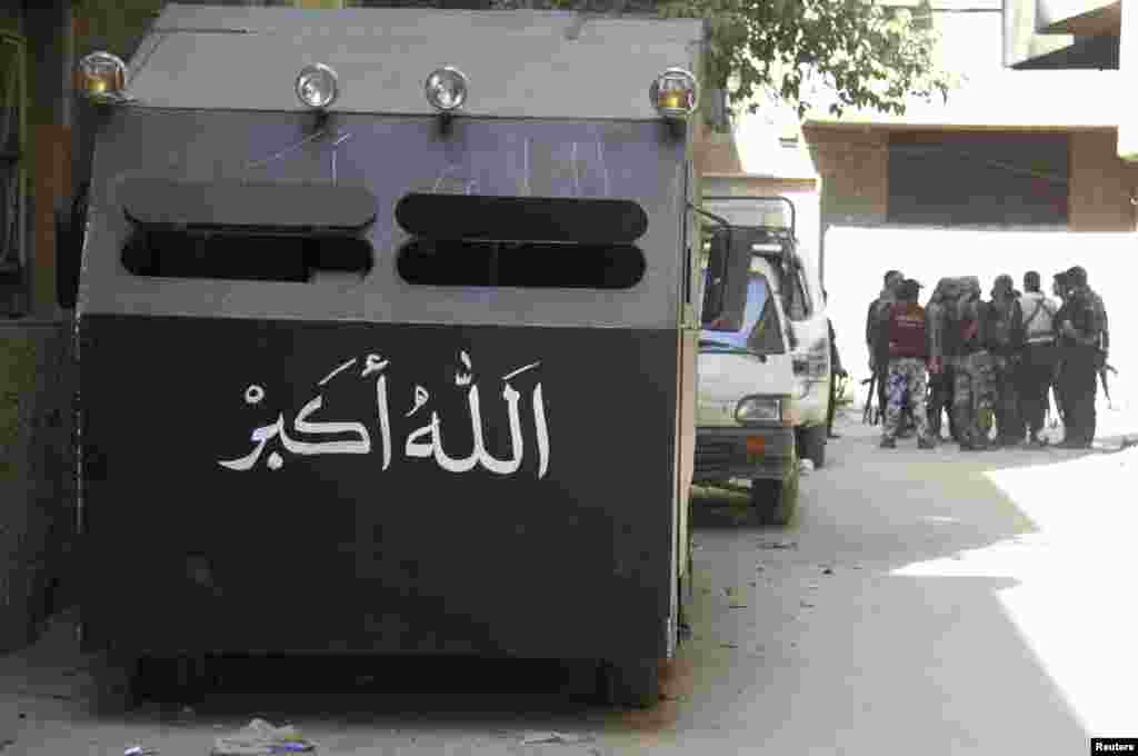 An armored vehicle is seen parked as Free Syrian Army fighters gather on a street in the refugee camp of Yarmouk, near Damascus, May 5, 2013.