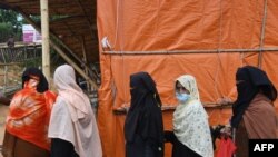 Rohingya refugees wait in to collect relief supplies at Kutupalong refugee camp in Ukhia, Bangladesh, Oct. 15, 2020. 