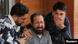 FILE - Relatives of a student who was injured during an attack by Taliban gunmen on the Army Public School comfort each other outside Lady Reading Hospital in Peshawar, Dec. 16, 2014.