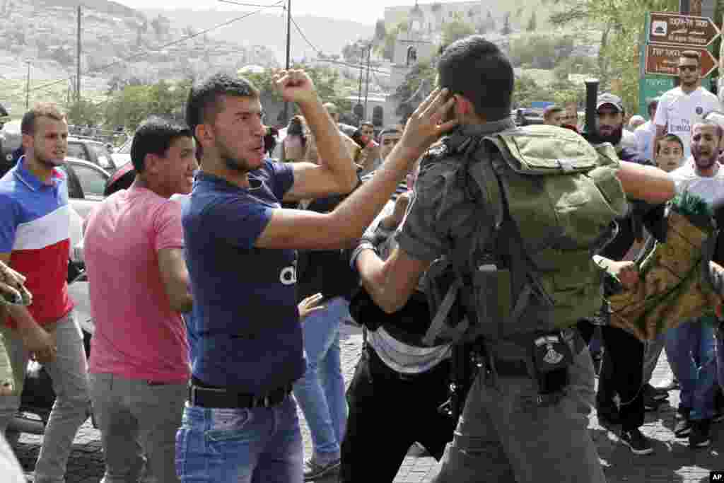 An Israeli border policeman exchanges blows with a Palestinian man during a confrontation after Friday prayers outside the Old City in Jerusalem, Oct. 2, 2015.&nbsp;