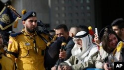 Warga Palestina menyaksikan pertunjukan yang digelar oleh anggota pramuka Kristen di Manger Square, di luar Gereja Kelahiran Yesus (the Church of the Nativity) di Kota Bethlehem, Tepi Barat, Sabtu, 24 Desember 2016.