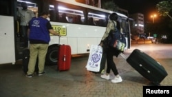 Una trabajadora doméstica migrante de África lleva su equipaje hacia un autobús que la llevaría con otras personas al aeropuerto para regresar a sus países de origen, en un suburbio de Beirut, Líbano, el 5 de octubre de 2020.