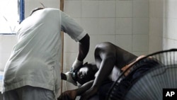 A man receiving treatment at a health clinic after being shot in the hip by security forces loyal to Laurent Gbagbo in the Anyama suburb of Abidjan, March 12, 2011