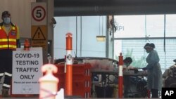 Staff work at a COVD-19 testing station in Melbourne, Australia, Feb. 4, 2021. 