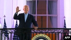 Presiden AS Joe Biden melambaikan tangan dari balkon di Gedung Putih, saat ia tiba untuk menyaksikan pesta kembang api menyambut Hari Kemerdekaan AS di Washington, DC, pada 4 Juli 2024. (Foto: AFP/Mandel Ngan)