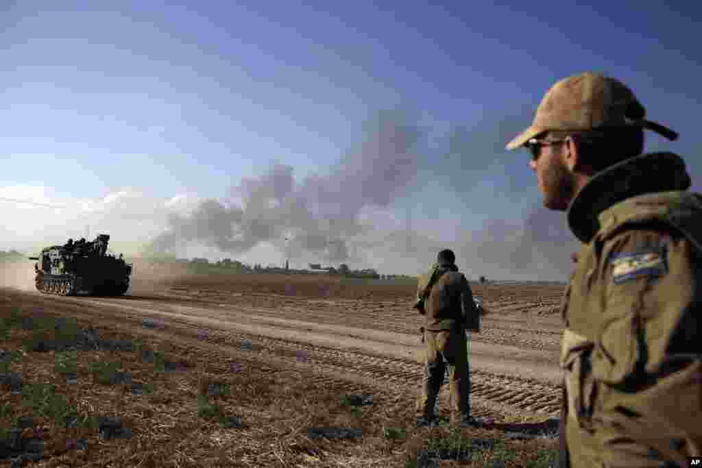 An Israeli armored personnel carrier advances as smoke rises from the Gaza Strip, July 20, 2014.