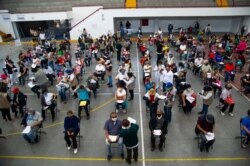 People wait to receive the first dose of China's Sinovac Biotech CoronaVac vaccine against COVID-19, in Ecatepec, Mexico state, Feb. 22, 2021.