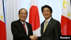 Philippines' President Benigno Aquino shakes hands with Japan's Prime Minister Shinzo Abe (R) at the start of their meeting at the prime minister's official residence in Tokyo, June 24, 2014.