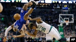 Gerald Henderson, de l'équipe de Philadelphie, tombe en essayant de bloquer Marcus Smart, de l'équipe de Boston, lors d'un match de la NBA, le 6 janvier 2017.