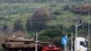 An Israeli military truck transports a tank in the Upper Galilee in northern Israel near the border with Lebanon on January 5, 2024.