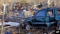 A vehicle sits among debris near Linden, Tenn., Dec. 24, 2015, following rare Christmastime tornadoes.