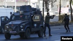 Plainclothes policemen react during a protest following a funeral ceremony for Kurdish militants in the southeastern city of Diyarbakir, Turkey, Dec. 24, 2015.