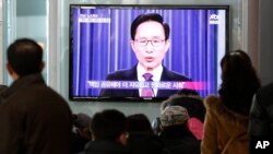 People watch a television airing a live broadcast of South Korean President Lee Myung-bak's retirement speech at Seoul Railway Station in Seoul, South Korea, February 19, 2013.