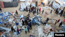 Palestinians inspect the damage at a tent camp sheltering displaced people, following an Israeli strike in Khan Younis on Dec. 18, 2024.