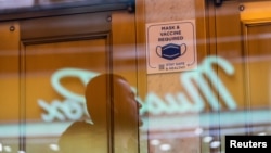 FILE - A sign posted on the door of a theater requiring patrons to be vaccinated against COVID-19, is seen in Times Square, in New York City, Dec. 16, 2021.