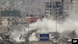 FILE - The Al-Qaboun neighborhood in rural Damascus is shelled, July 15, 2013. 
