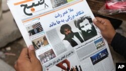 FILE - An Afghan man reads a local newspaper carrying a headline about the new leader of the Afghan Taliban, Mullah Akhtar Mansoor, in Kabul, Afghanistan, Aug. 1, 2015.
