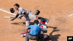 Miami Marlins' Miguel Rojas, left, reacts to getting hit by a pitch during the seventh inning of a baseball game, July 26, 2020, in Philadelphia. 