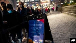 Patients wait to receive a COVID-19 vaccine booster shot at a mobile vaccination station on 59th Street below Central Park, Dec. 2, 2021, in New York.