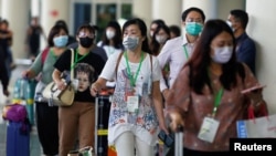 Passengers wearing medical masks are pictured at the international arrival terminal of I Gusti Ngurah Rai airport following an outbreak of the new coronavirus in China, in Bali, Indonesia, Feb. 4, 2020.