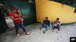 FILE - Honduran migrants making their way north to the US border, rest in Tecun Uman, Guatemala, Jan. 20, 2021, on the border with Mexico.