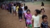 Children wait to receive gifts after a show to entertain them at the sports club where Central American migrants traveling with the annual Stations of the Cross caravan have been camped out in Matias Romero, Mexico, April 4, 2018. 