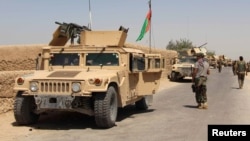 FILE - Afghan National Army (ANA) troops arrive in Nad Ali district of Helmand province, southern Afghanistan, Aug. 10, 2016.