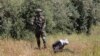 An Israeli soldier stands over handcuffed and blindfolded Osama Hajahjeh, 16, after he was shot near the village of Tekoa, West Bank, Apri 18, 2019. 