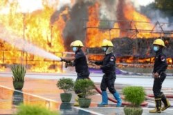 Firefighters spray water as flames and smoke rise from burning illegal drugs during a destruction ceremony to mark International Day Against Drug Abuse and Illicit Trafficking outside Yangon, Myanmar, June 26, 2020.