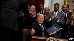 President Donald Trump shakes hands during an event to honor Dr. Martin Luther King Jr., in the Roosevelt Room of the White House, Jan. 12, 2018, in Washington.