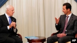 FILE - This SANA photo shows Syrian President Bashar al-Assad, right, speaking with U.N. envoy Staffan de Mistura in Damascus, Nov. 10, 2014.