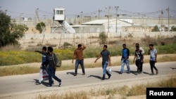African migrants walk on a road after being released from Saharonim Prison in the Negev desert, Israel, April 15, 2018. 