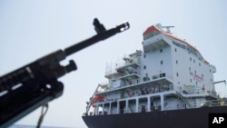 Sailors stand on deck above a hole the U.S. Navy says was made by a limpet mine on the damaged Japanese owned oil tanker Kokuka Courageous, anchored off Fujairah, United Arab Emirates. during a trip organized by the Navy for journalists, June 19, 2019. 