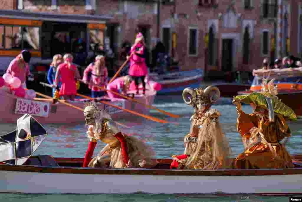 Para pengunjung ikut bersuka ria selama parade topeng di Grand Canal dalam acara karnaval tahunan di kota Venesia, Italia. (Reuters)&nbsp;
