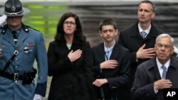 The family of Martin Richard, from left, mother Denise, brother Henry, and father Bill Richard, with former Boston Mayor Tom Menino, right, during a tribute in honor of the one year anniversary of the Boston Marathon bombings, Apr. 5, 2014, in Boston. 