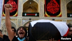 FILE - Mourners carry the coffin of Reham Yacoub, a female activist who was killed by unidentified gunmen, during her funeral in the holy city of Najaf, Iraq, Aug. 20, 2020. 