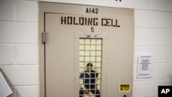 A detainee sits in a holding cell at the Stewart Detention Center in Lumpkin, Ga., Nov. 15, 2019. 